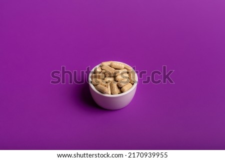 Flat lay view of nutritional supplements and multivitamins for help to support high immune system. Vitamins to avoid illnesses. Top view of vitamins on bright purple background. Pills and medications. Royalty-Free Stock Photo #2170939955