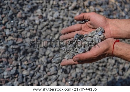 Crushed stones in the hands of a man. Selective focus. Nature.