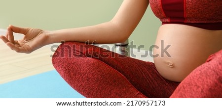 Beautiful pregnant woman practicing yoga in gym, closeup. Zen concept