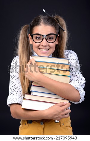 Young nerd woman crazy expression in glasses, holding book in hands on black background