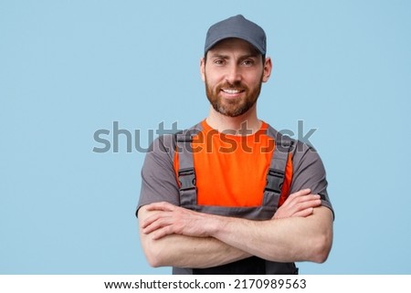 Portrait of smiling workerman in uniform with crossed hands looking at camera Royalty-Free Stock Photo #2170989563