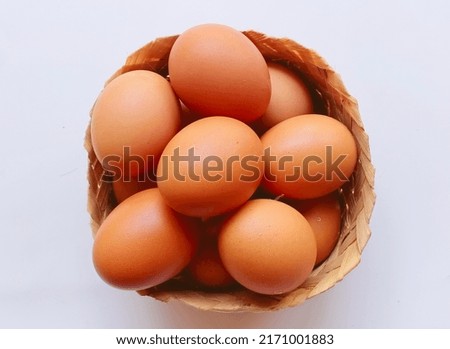 chicken eggs in a bamboo basket on white background