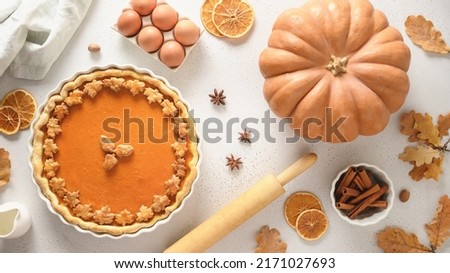Thanksgiving Day American Pumpkin Pie with ingredients for baking on white background. View from above. Flat lay.
