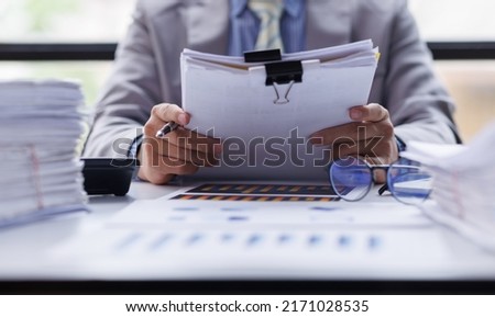Business Documents, Auditor businesswoman checking searching document legal prepare paperwork or report for analysis TAX time,accountant Documents data contract partner deal in workplace office Royalty-Free Stock Photo #2171028535