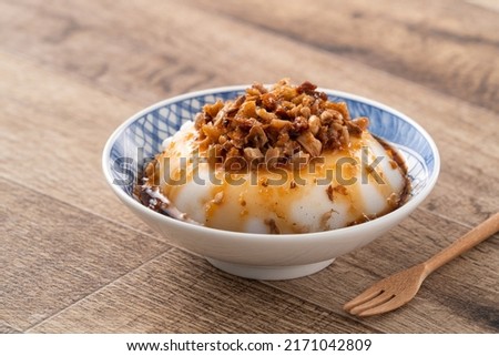 Taiwanese savory rice pudding Wa gui, rice cake with chopped dried radish topping and soy sauce in a bowl. Royalty-Free Stock Photo #2171042809