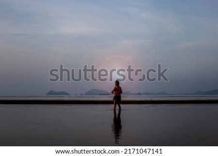 woman standing by the sea at sunrise