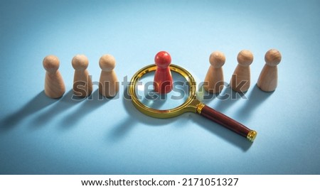 Magnifying glass and wooden human figures. 

Management. Candidate selection