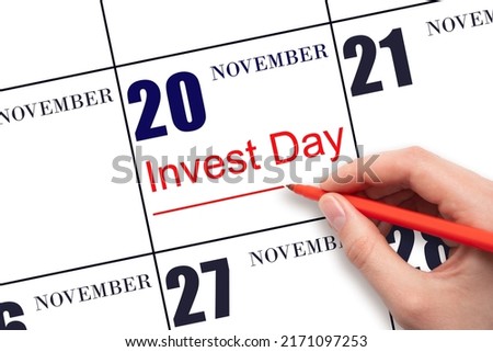 20th day of November. Hand drawing red line and writing the text Invest Day on calendar date November 20.  Business and financial concept. Autumn month, day of the year concept.