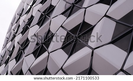 Modern architecture. Panels like honeycombs, unusual panels. Geometric shape. Part of a modern building. The building is assembled from geometric panels of hexagonal shapes - a hexagon. On a white bac Royalty-Free Stock Photo #2171100533