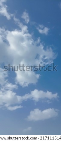 Beautiful white clouds on deep blue sky background. Elegant blue sky picture in daylight. Large bright soft fluffy clouds are cover the entire blue sky. Cumulus clouds in clear blue sky. No focus