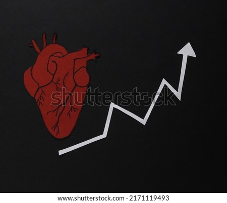 Statistics, analysis of cardiovascular diseases, risk of heart attack or stroke. Anatomical heart with growth arrow on black background