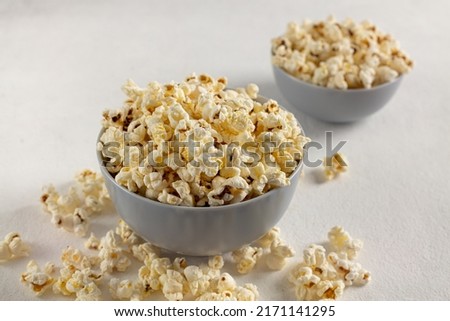 A bowl of delicious popcorn on a light background, natural delicious food for watching a movie