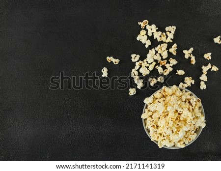 A bowl of delicious popcorn on a dark background, natural delicious food for watching a movie