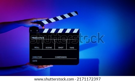 Movie Clapper board. Crew hand holding plastic and wooden film slate board against camera. Movie clapperboard using in video production and movie studio works film industry. Film slate on crew hand.