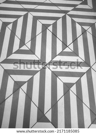 Pavement background texture: black and white square stone tiles with abstract pattern. Interior covering of floor, geometric graphic paving in perspective