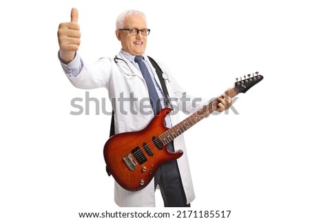 Cheerful male doctor with an electric guitar showing thumbs up isolated on white background