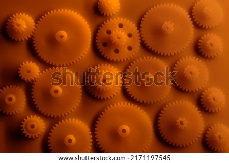 Plastic gears compilation on an orange background. Spare parts for your RC toy. Background picture.