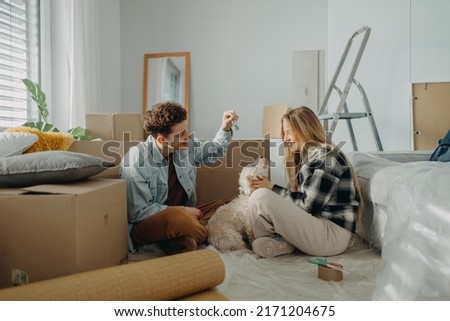 Cheerful young couple in their new apartment. Conception of moving. Royalty-Free Stock Photo #2171204675