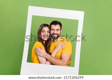 Photo of two idyllic peaceful partners cuddle paper album card moment isolated on green color background