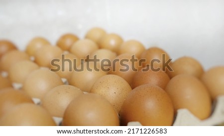 Chicken eggs piled together in a panel.