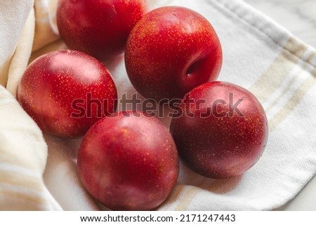 Plumcot. Organic fruits. Vegetarian 
Healthy vegetarian diet. A plumcot is a cross between a plum and an apricot. Organic ripen fresh plumcots. Sweet and juicy fruits.  Royalty-Free Stock Photo #2171247443