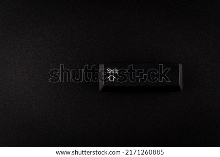 black Shift button from keyboard on black background with copy space.