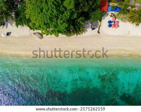 Drone shots of beach with Turquoise Blue Sea in Perhentian Islands, Malaysia. Beautiful sand and waves.