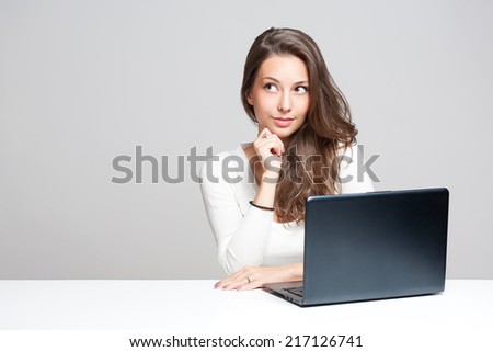 Young brunette beauty with a black laptop computer.