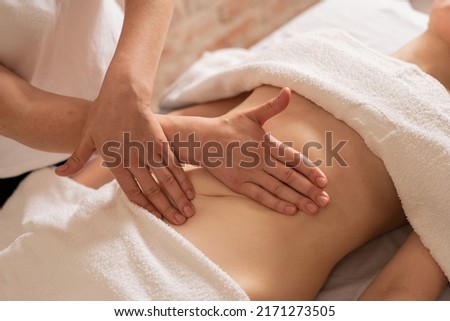 relaxing massage and body shaping massage, lymphatic drainage, manual and aesthetic procedures, hands massaging belly in the spa salon Royalty-Free Stock Photo #2171273505