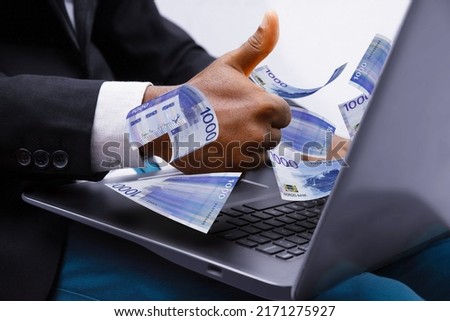 1000 Norwegian krone notes coming out of laptop with Business man giving thumbs up, Financial concept. Make money on the Internet, working with a laptop