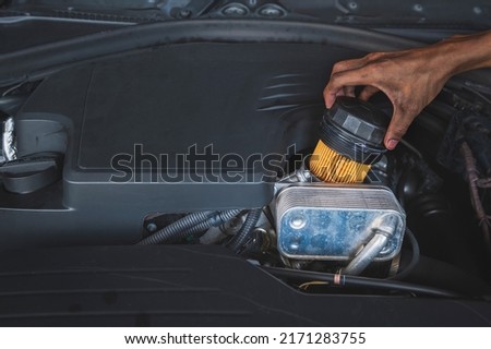 Auto mechanic changing an engine oil filter. Royalty-Free Stock Photo #2171283755