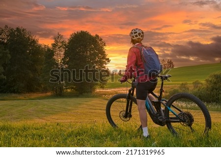 active woman riding her electric mountain bike at sunset in the Bregenz Forest mountains near Sulzberg, Vorarlberg, Austria Royalty-Free Stock Photo #2171319965
