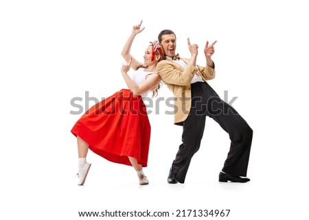 Expressive couple of dancers in vintage retro style outfits dancing social dance isolated on white background. Timeless traditions, 60s ,70s american fashion style. Dancers look excited