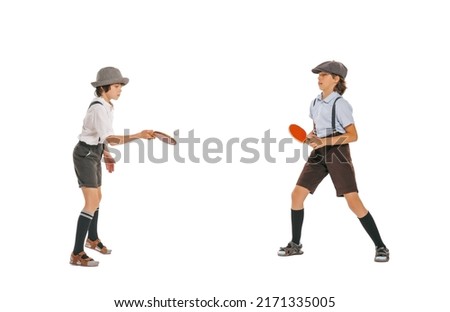 Leisure activity. Two school age boys, stylish kids wearing retro clothes playing ping-pong isolated over white background. Concept of childhood, sport, hobby, games. Copy space for ad