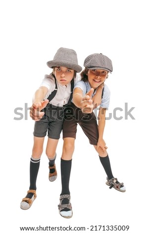 Wide angle view of two school age boys, stylish kids wearing retro clothes isolated over white background. Concept of childhood, vintage summer fashion style. Copy space for ad