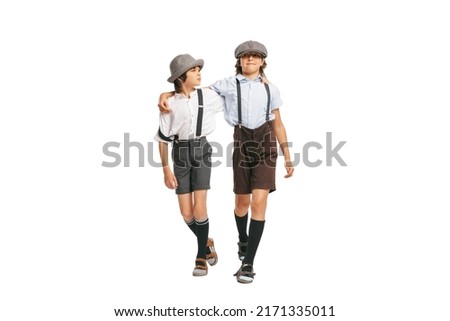 Friends. Two school age boys, stylish kids wearing retro clothes isolated over white background. Concept of childhood, vintage summer fashion style. Copy space for ad