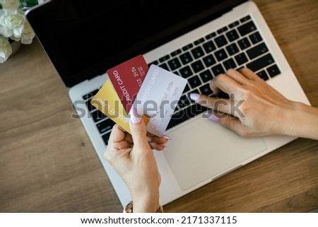 Online shopping concept. Close-up human hands holding a credit card on laptop background.