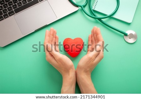 Female doctor with the stethoscope holding heart. High quality photo
