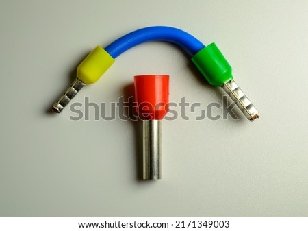 Blue cable with yellow and green ferrules and big red ferrule in the middle of composition. Royalty-Free Stock Photo #2171349003