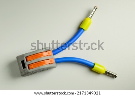 Electrical terminal for quick connection of wires with connected blue wires with yellow ferrules - macro photo. Background picture. Selective focus. Royalty-Free Stock Photo #2171349021