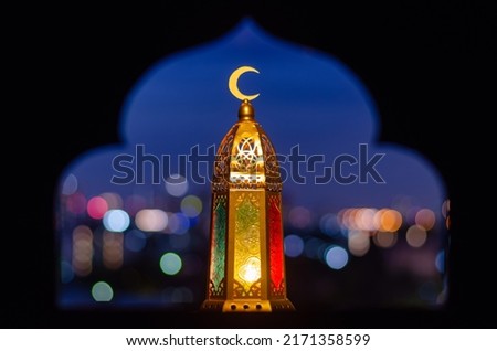 Lantern that have moon symbol on top with blurred focus of paper cut for mosque shape background. Ramadan Kareem and Islamic new year concept. Royalty-Free Stock Photo #2171358599