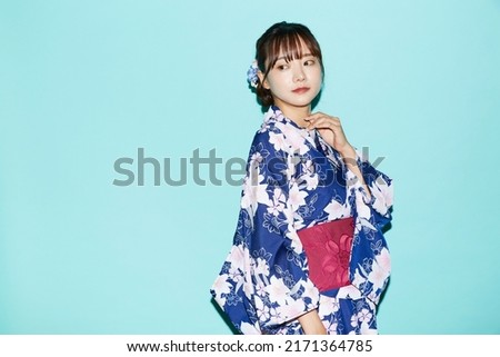 Portrait of young woman in yukata on blue background
