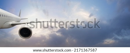 Travel by plane. International flight. Airplane flying in blue sky with clouds on sunset time
