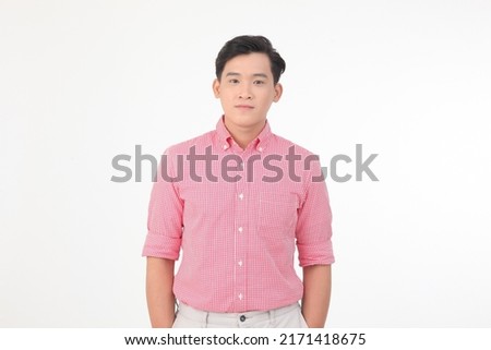 Portrait of a young Asian handsome man in red shirt, hand gesture point to the air to show message, isolated on white background