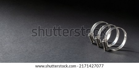 Metal hose clamp on black background. Empty space for text Royalty-Free Stock Photo #2171427077