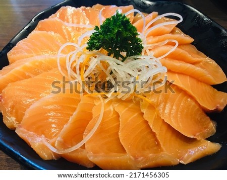 Fresh Salmon, Sashimi on a plate, a popular Japanese dish. Garnished with radish sliced into strips.