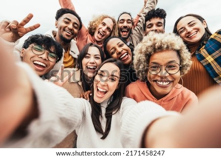 Big group of friends taking selfie picture smiling at camera - Laughing young people celebrating standing outside and having fun - Portrait photography of teens guys and girls enjoying vacation Royalty-Free Stock Photo #2171458247