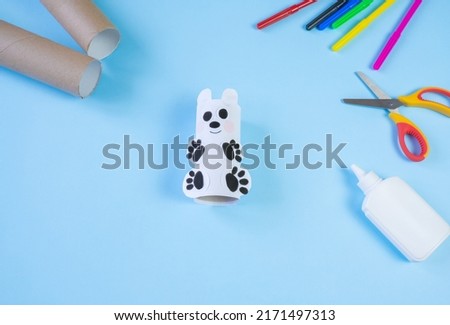 Festive easy DIY craft for children. Roll of toilet paper toy bear on a blue background. Creative decoration eco friendly, reuse, recycling, minimal waste free handmade concept