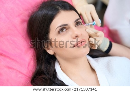 Woman doctor makes an injection against aging and dark circles under the eyes