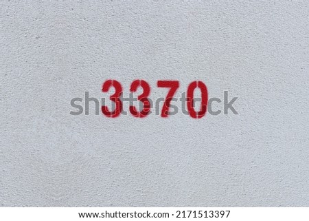 Red Number 3370 on the white wall. Spray paint.
